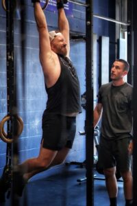 Personal trainer in Calgary guiding a client through a workout session at CrossFit Sunalta, helping them achieve their SMART fitness goals.